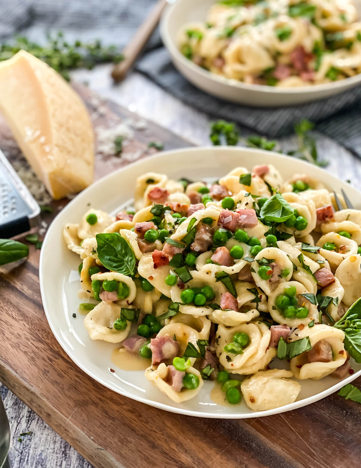 Italian pasta with ham and peas on a board
