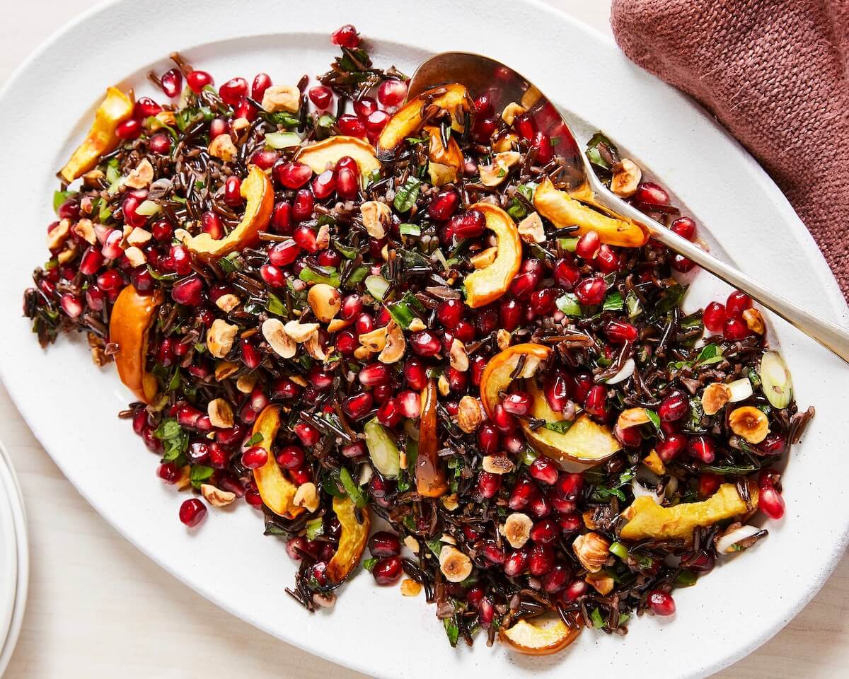 wild rice salad with nuts and pomegranates on a white platter