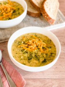 table scene with broccoli cheddar soup bowls and bread slices