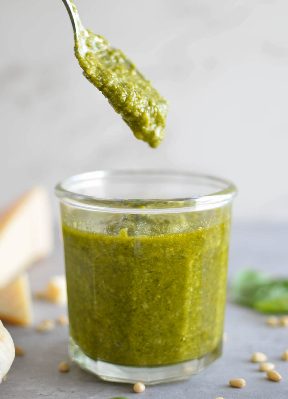 dripping pesto sauce from spoon into jar