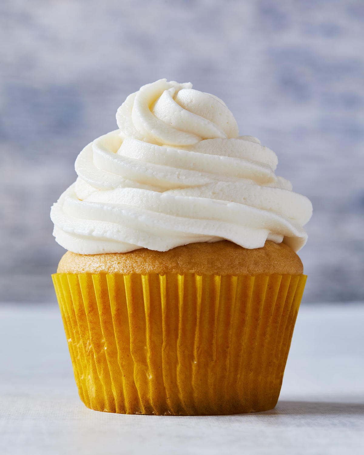 single cupcake with vanilla frosting
