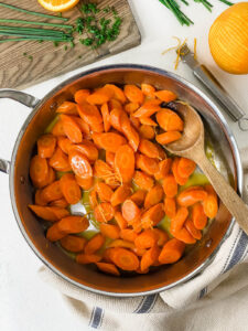 orange glazed carrots cooking in pan