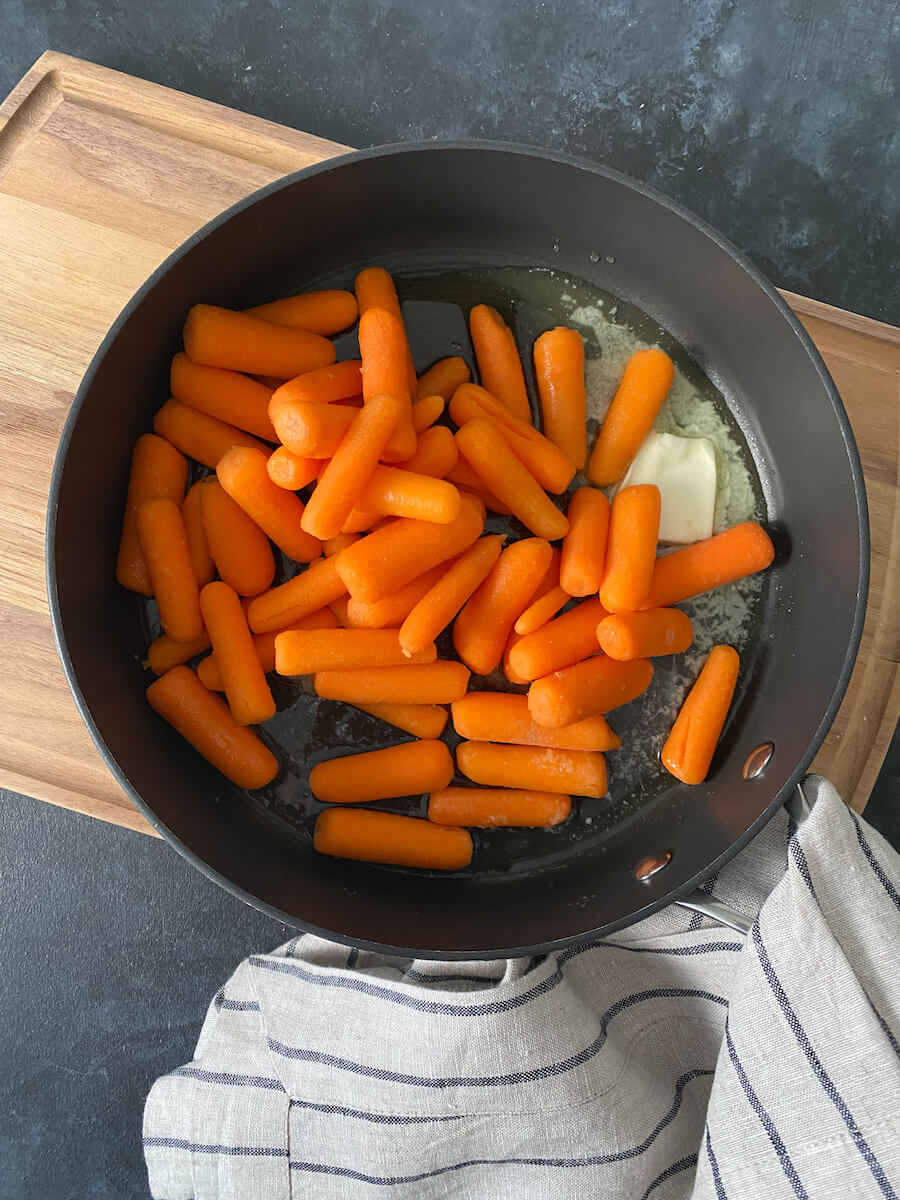 baby carrots with honey and butter in a pan