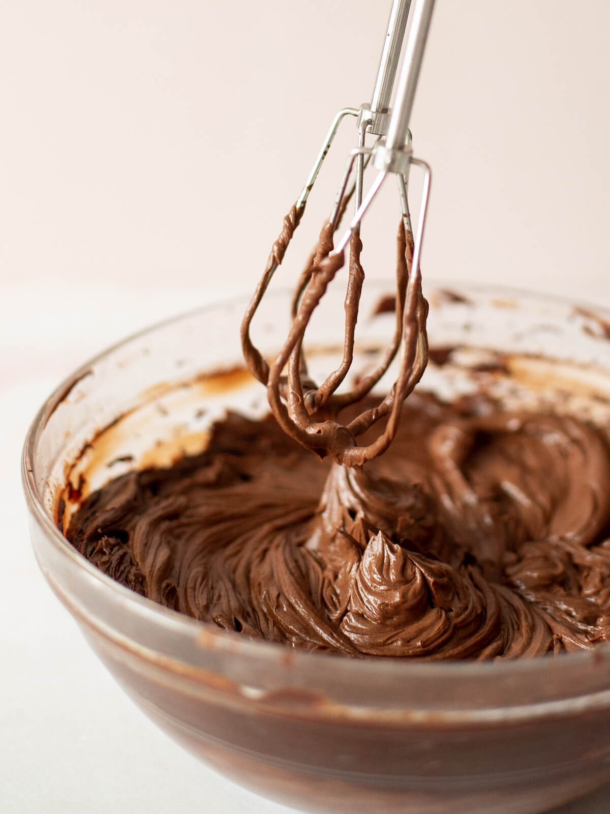 whipping chocolate frosting in a bowl