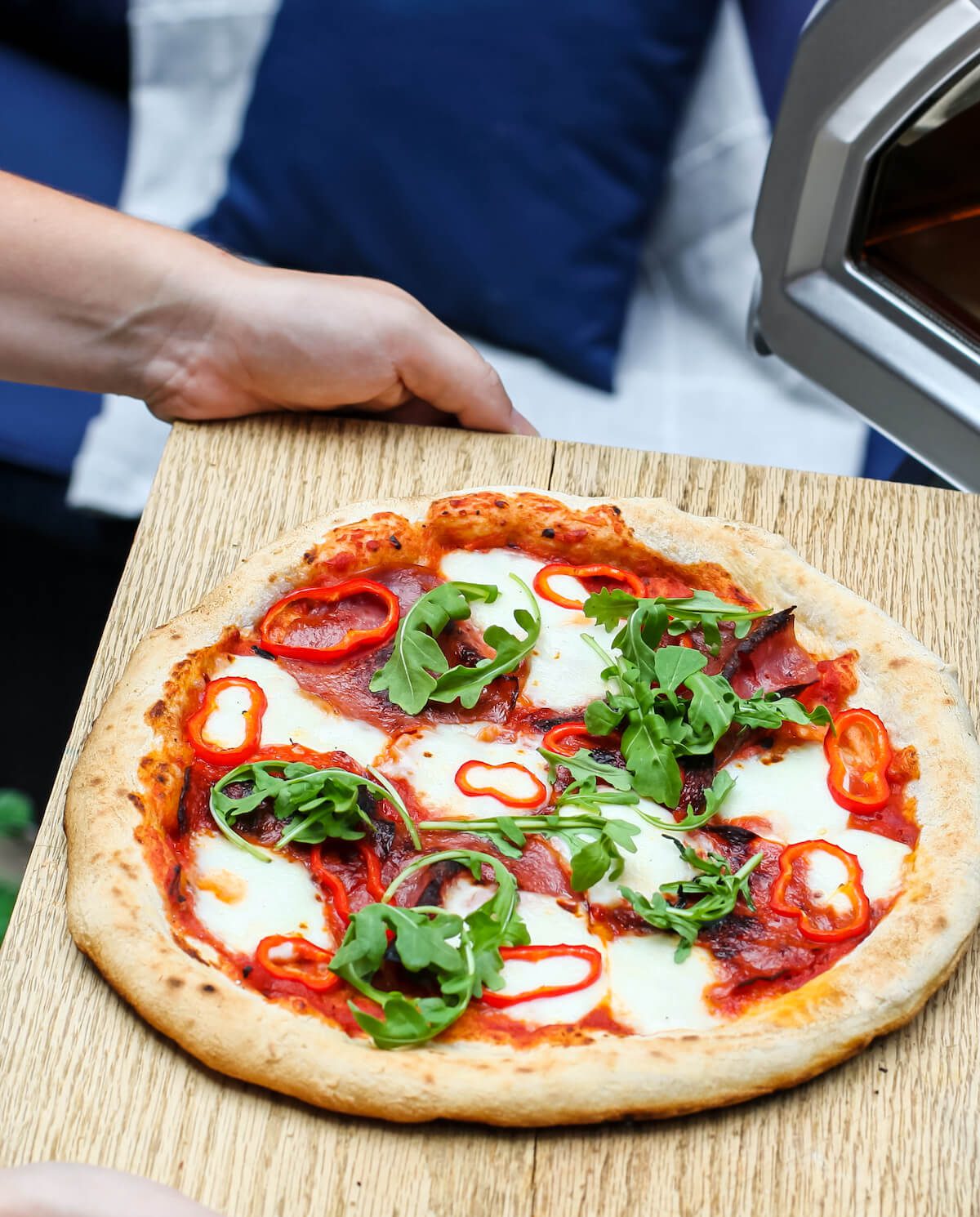 arugula and pepper pizza on cutting board