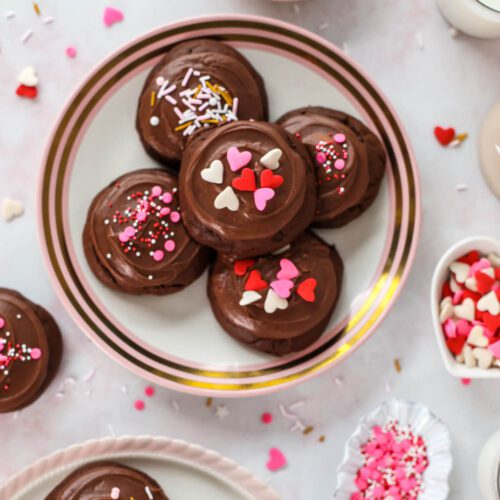 cookies with frosting and valentines sprinkles on a plate