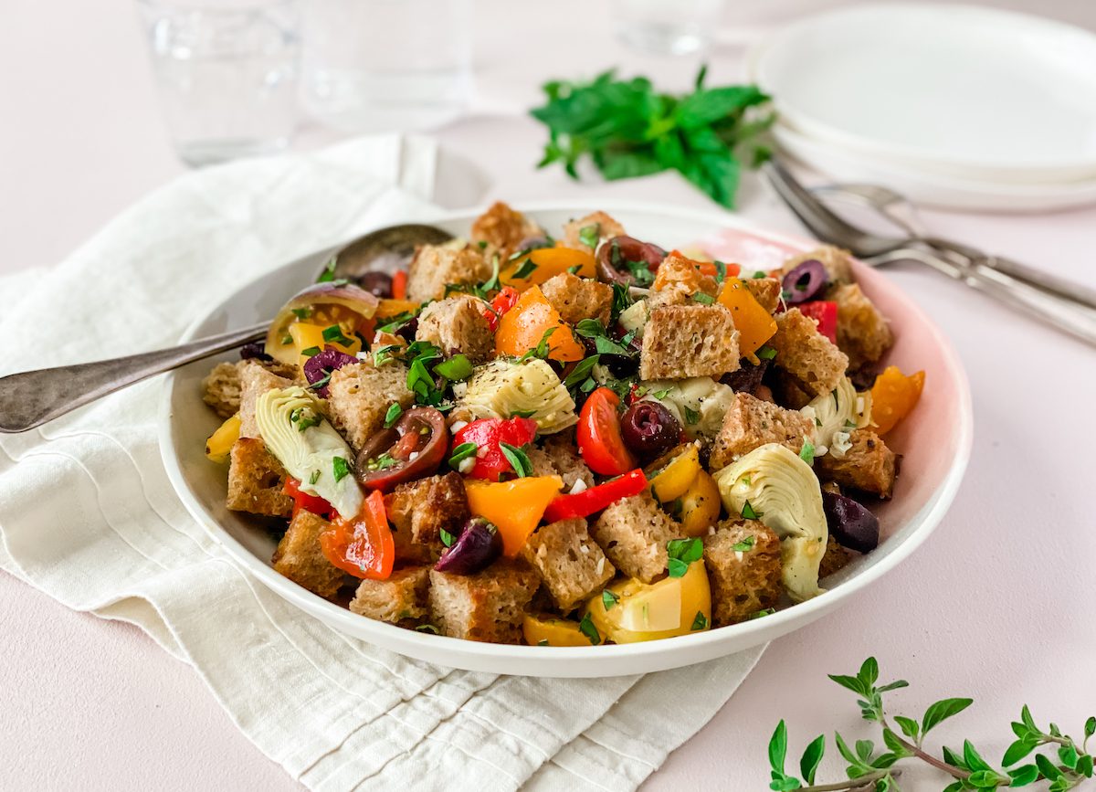 summer bread salad with tomatoes and artichokes in a bowl
