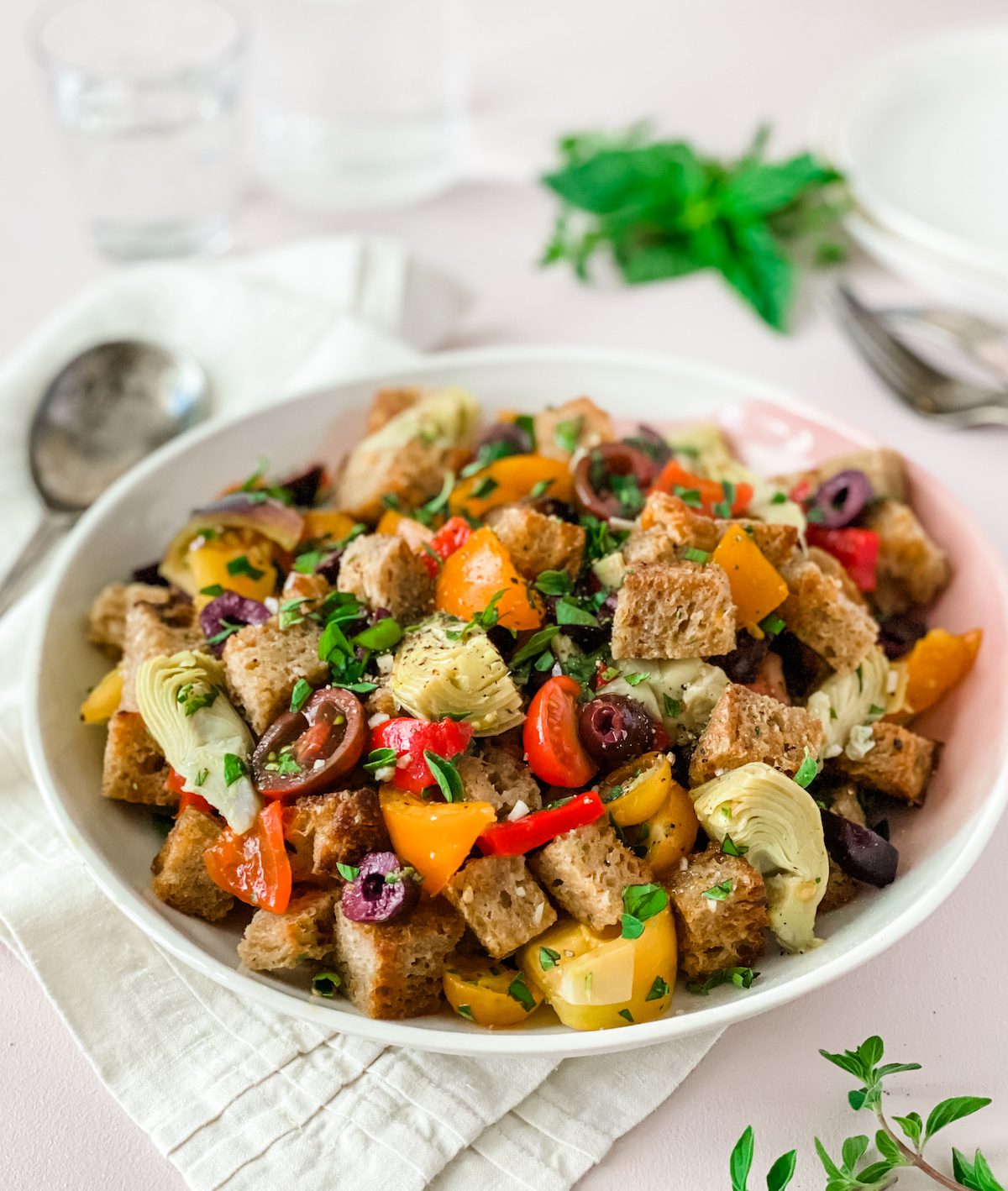 Panzanella bread salad with olives, tomatoes and artichokes with fresh herbs
