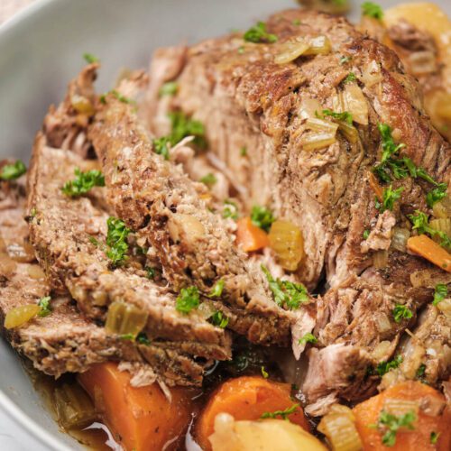 close up of sliced classic pot roast with carrots and potatoes