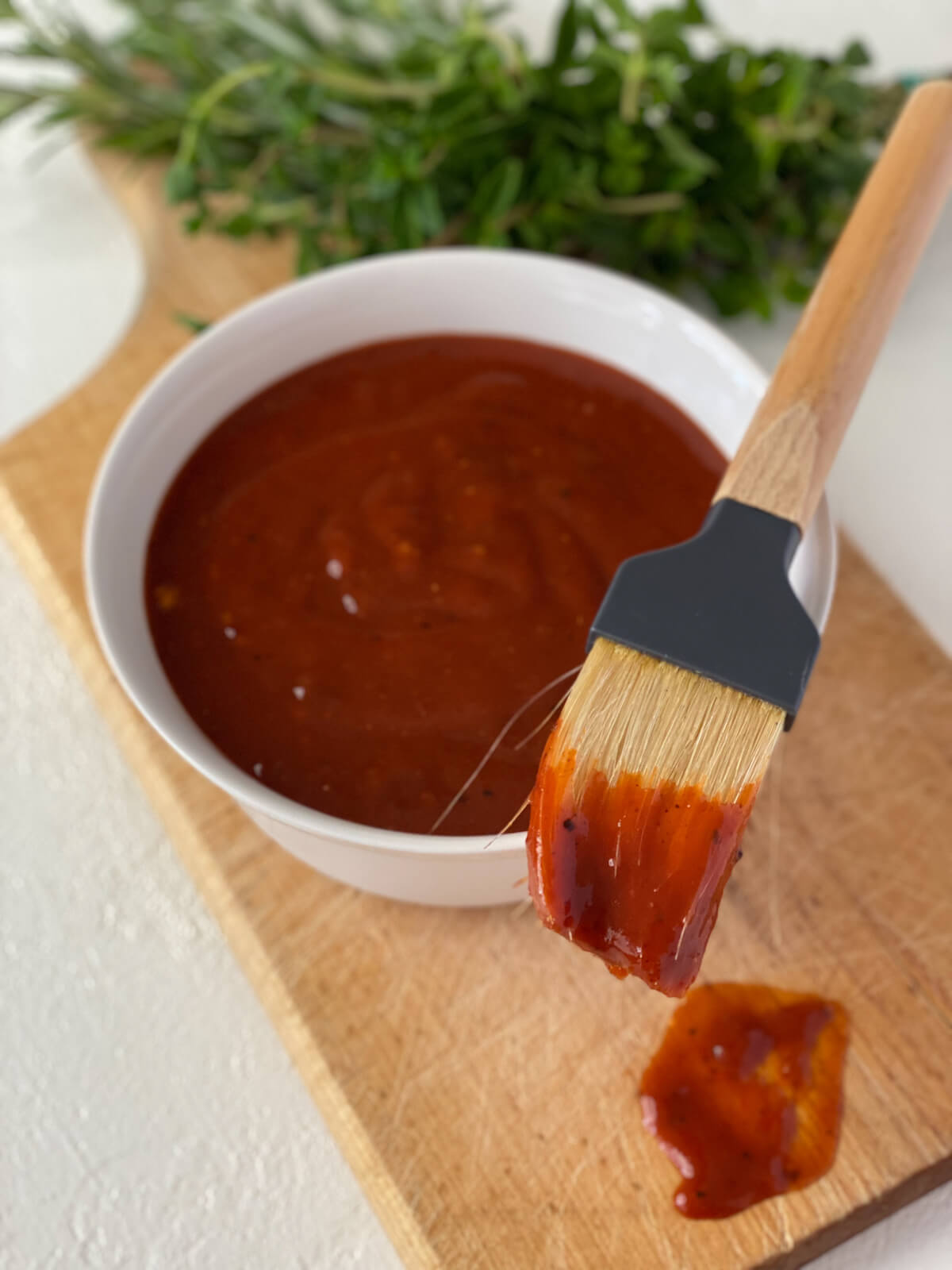 Homemade BBQ sauce with brush and herbs