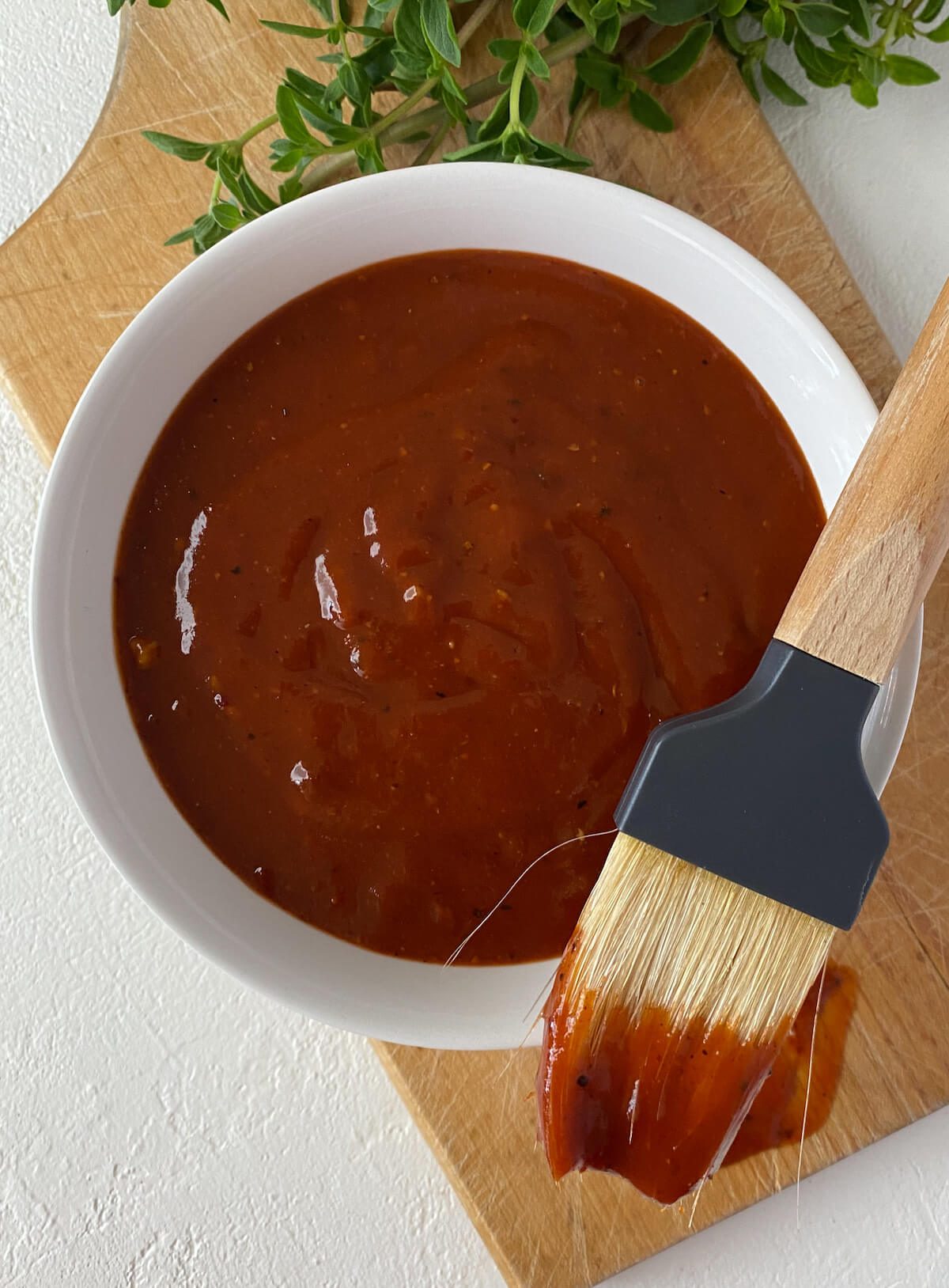 BBQ sauce in a bowl with a brush