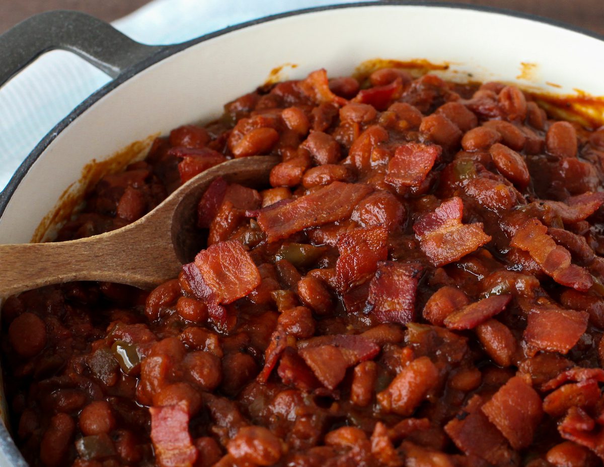 super close up of bacon in BBQ baked beans