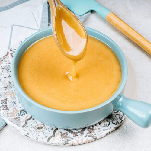 hot caramel icing in a blue bowl with spoon