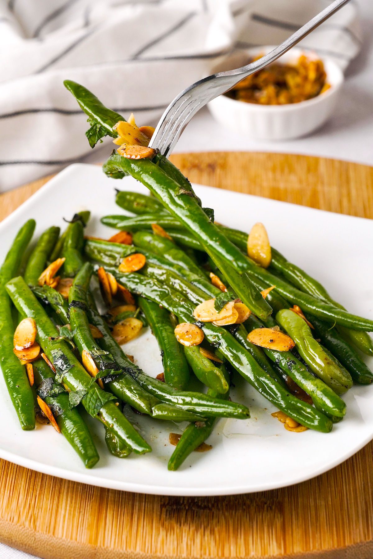 Green beans with almonds with a fork on a plate