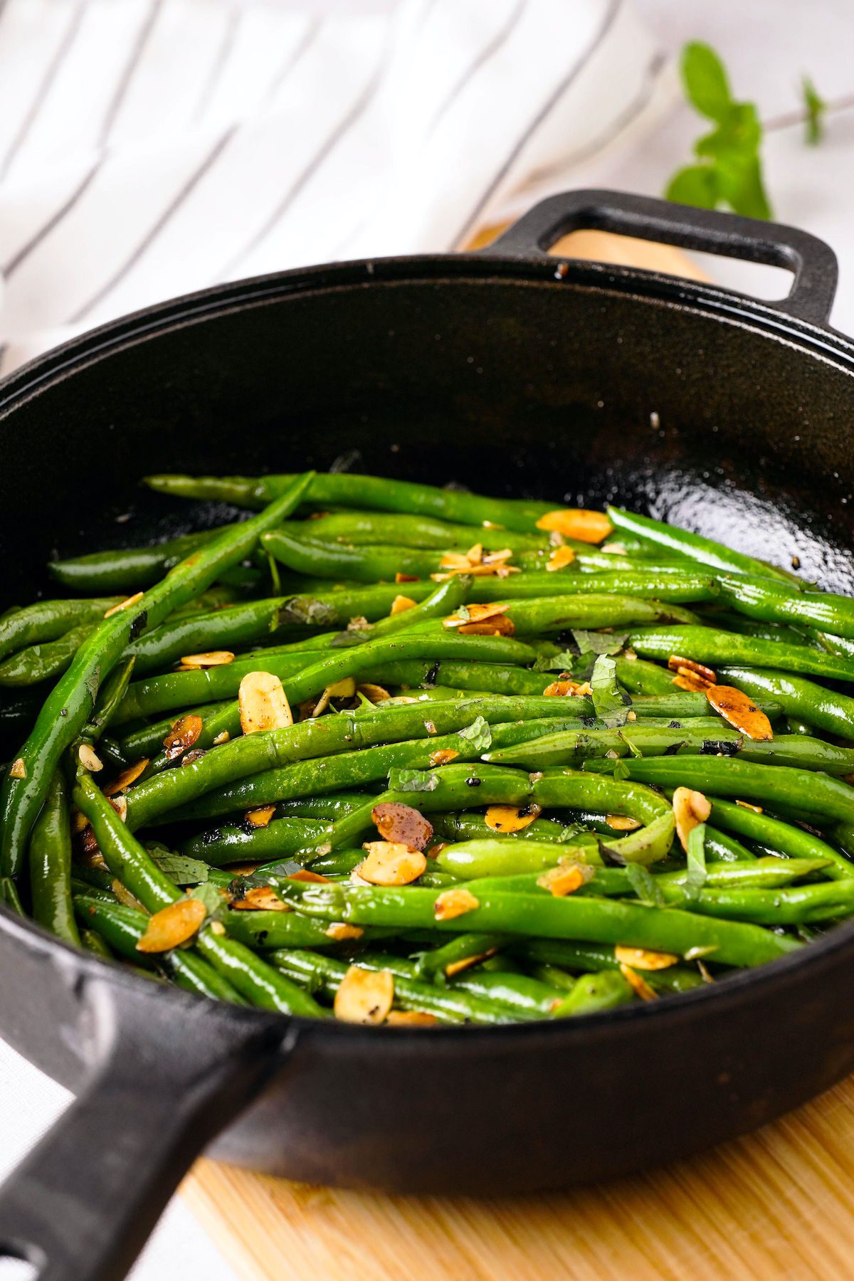 cooked green beans and almonds in a cast iron skillet
