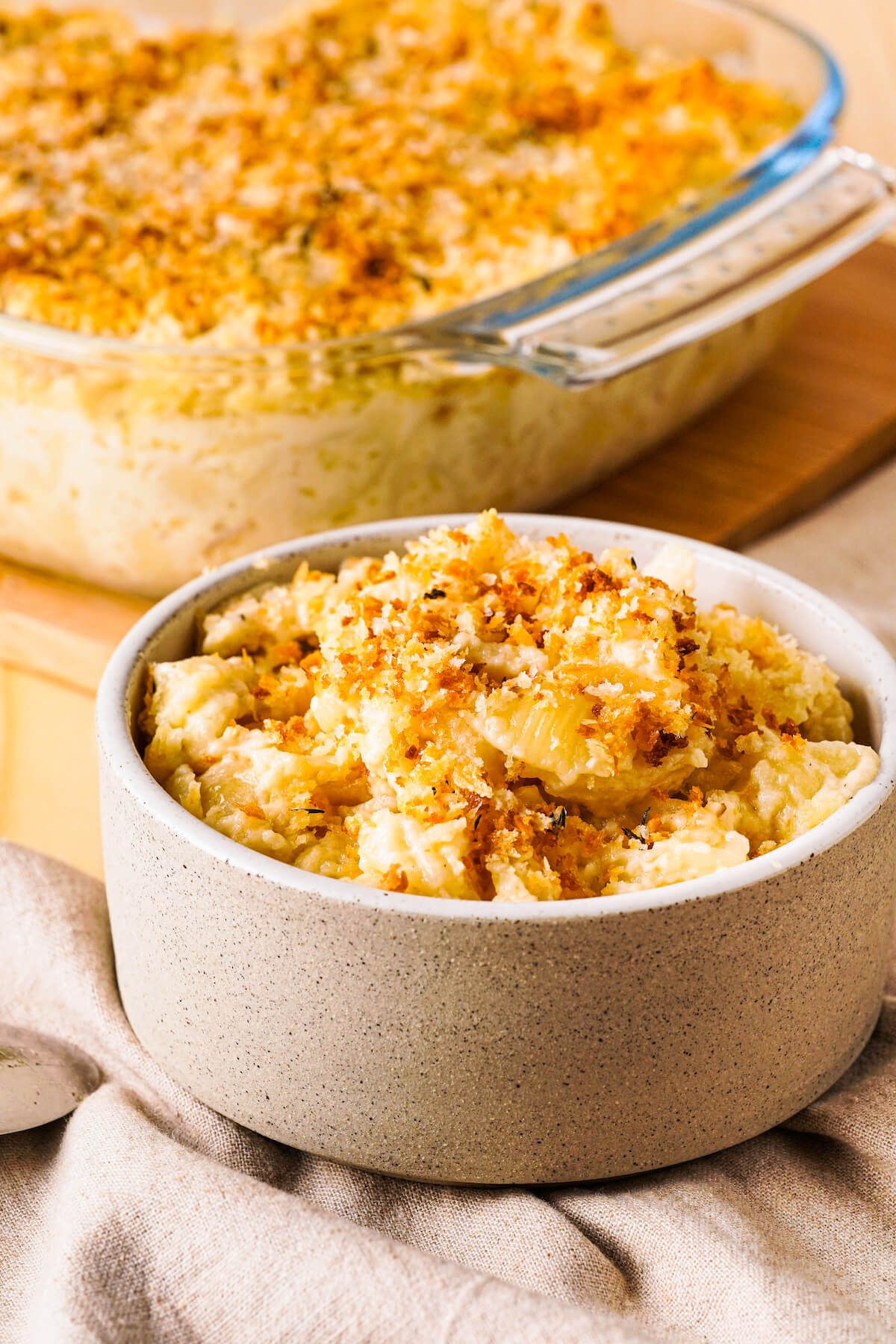 small dish of shell mac and cheese with breadcrumbs on top.