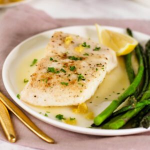 a plate of lemon butter fish with asparagus
