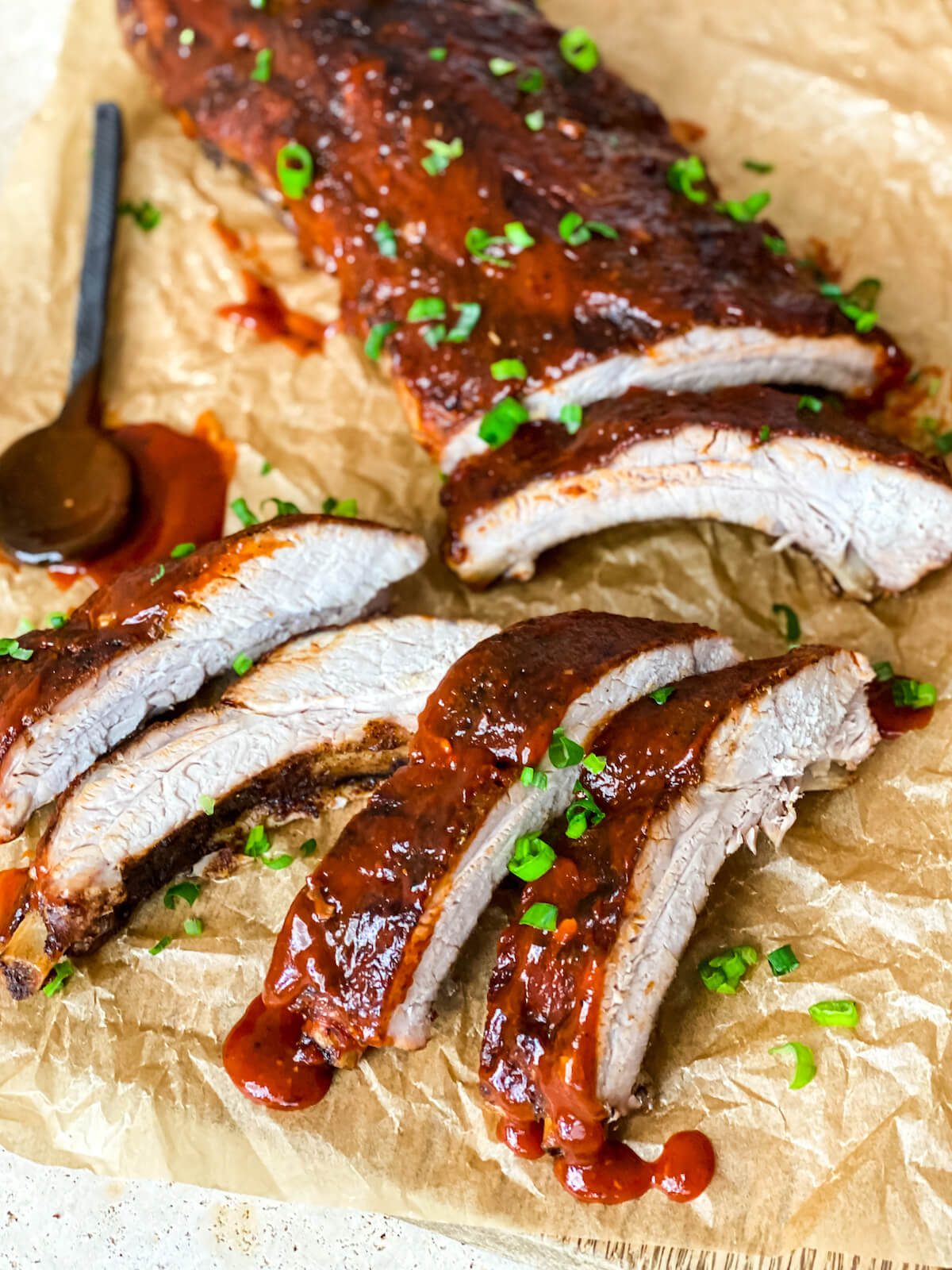 cut up rack of bbq ribs on parchment paper