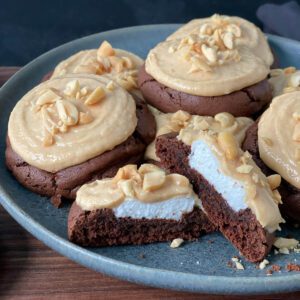 close up of inside chocolate peanut butter marshmallow surprise cookies on a plate.