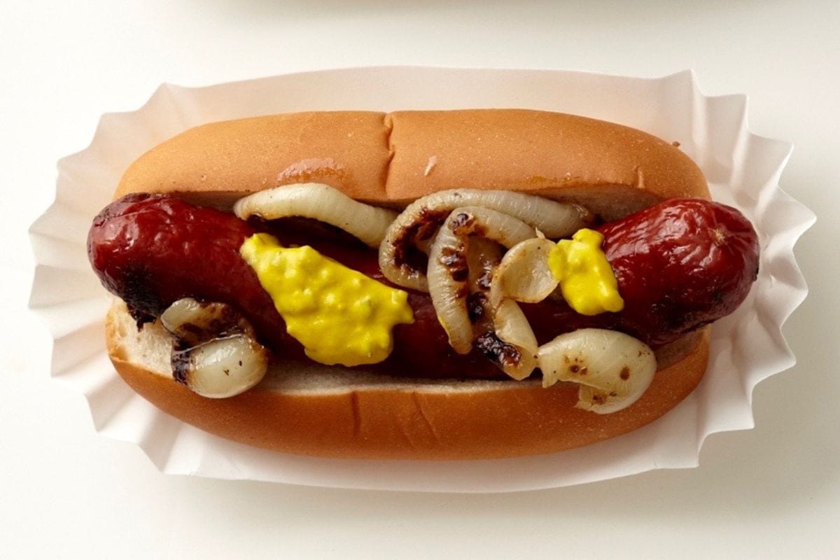 Bison sausage in a bun with toppings.