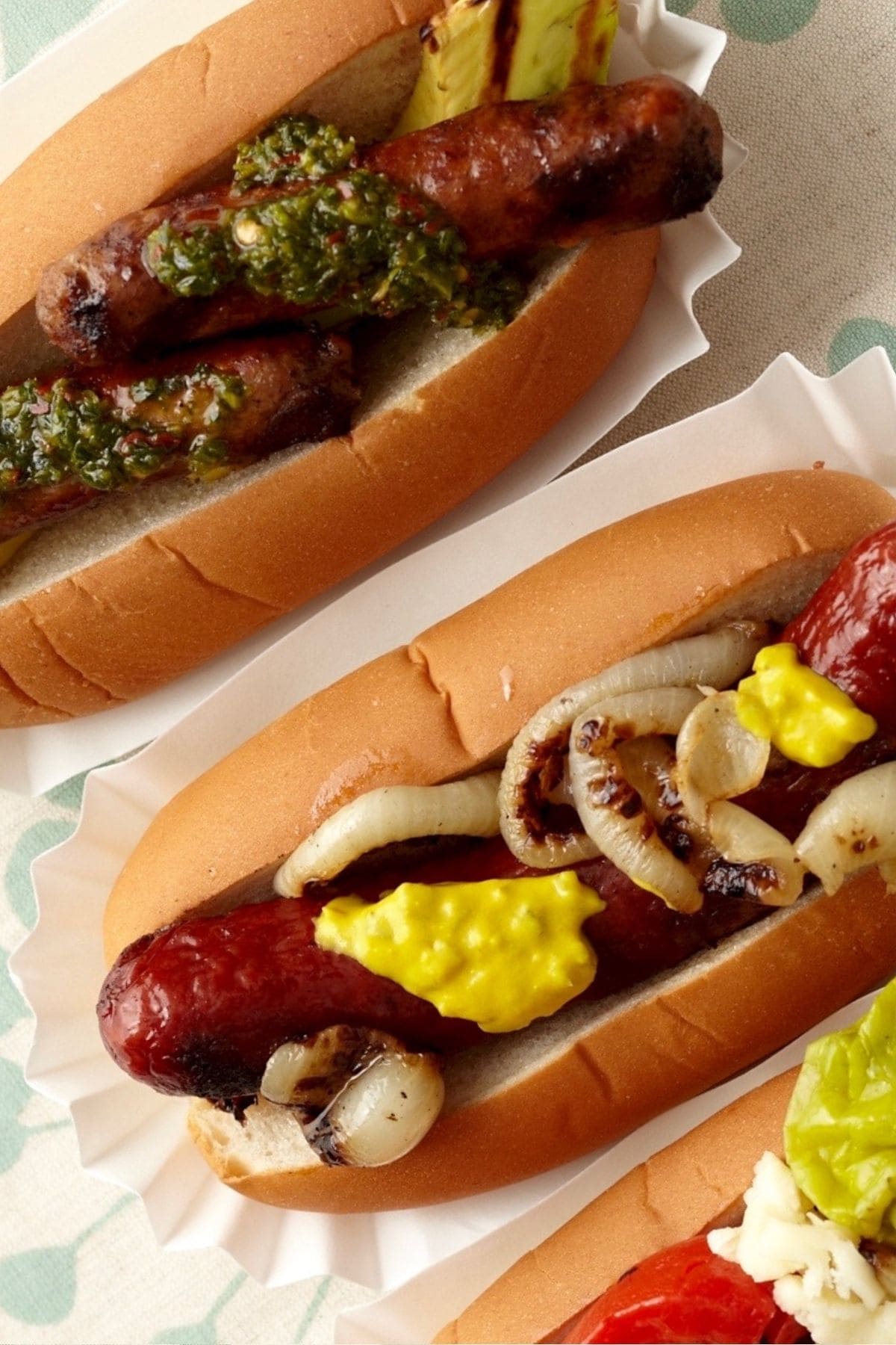 Close up of two gourmet hot dogs at an angle.