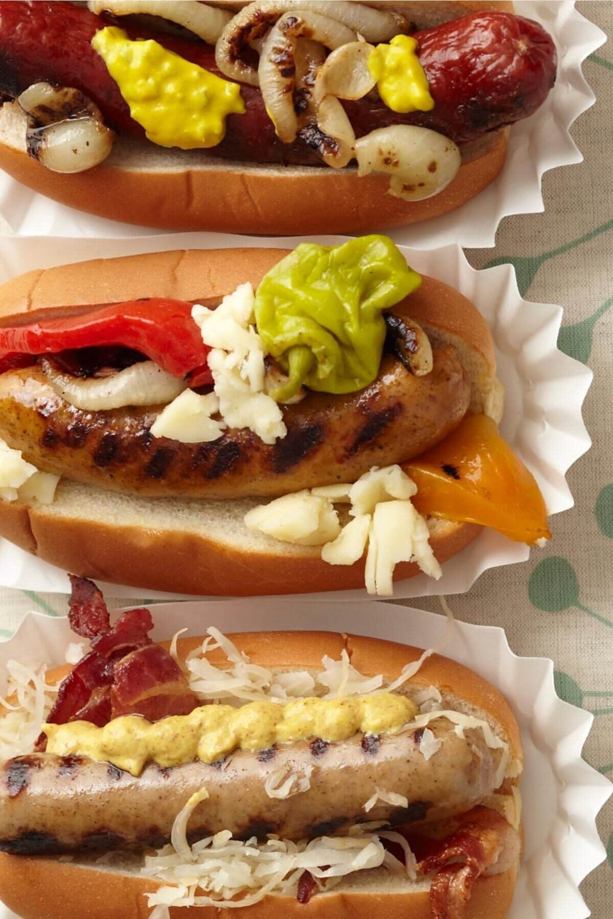 Close up of three gourmet hot dogs in a row.