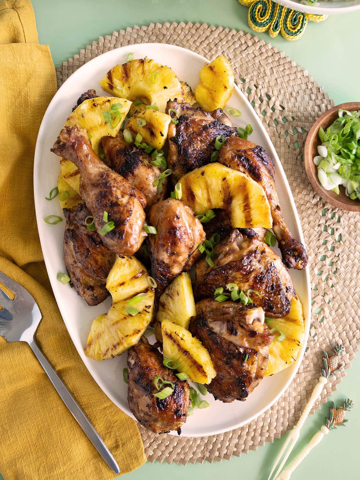 Top view of a platter of grilled chicken and pineapple. 