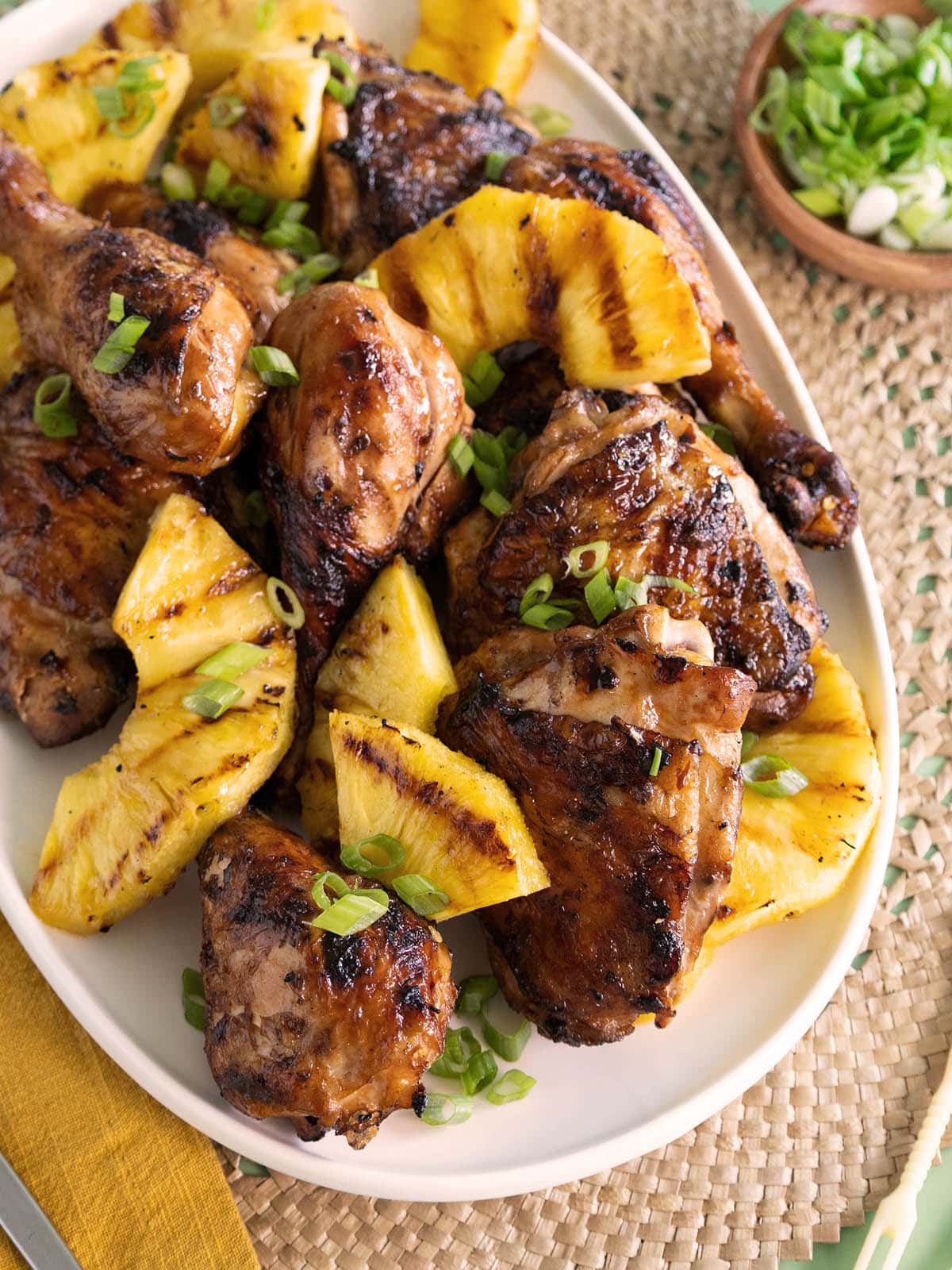 Close up of a platter of grilled chicken and pineapple.