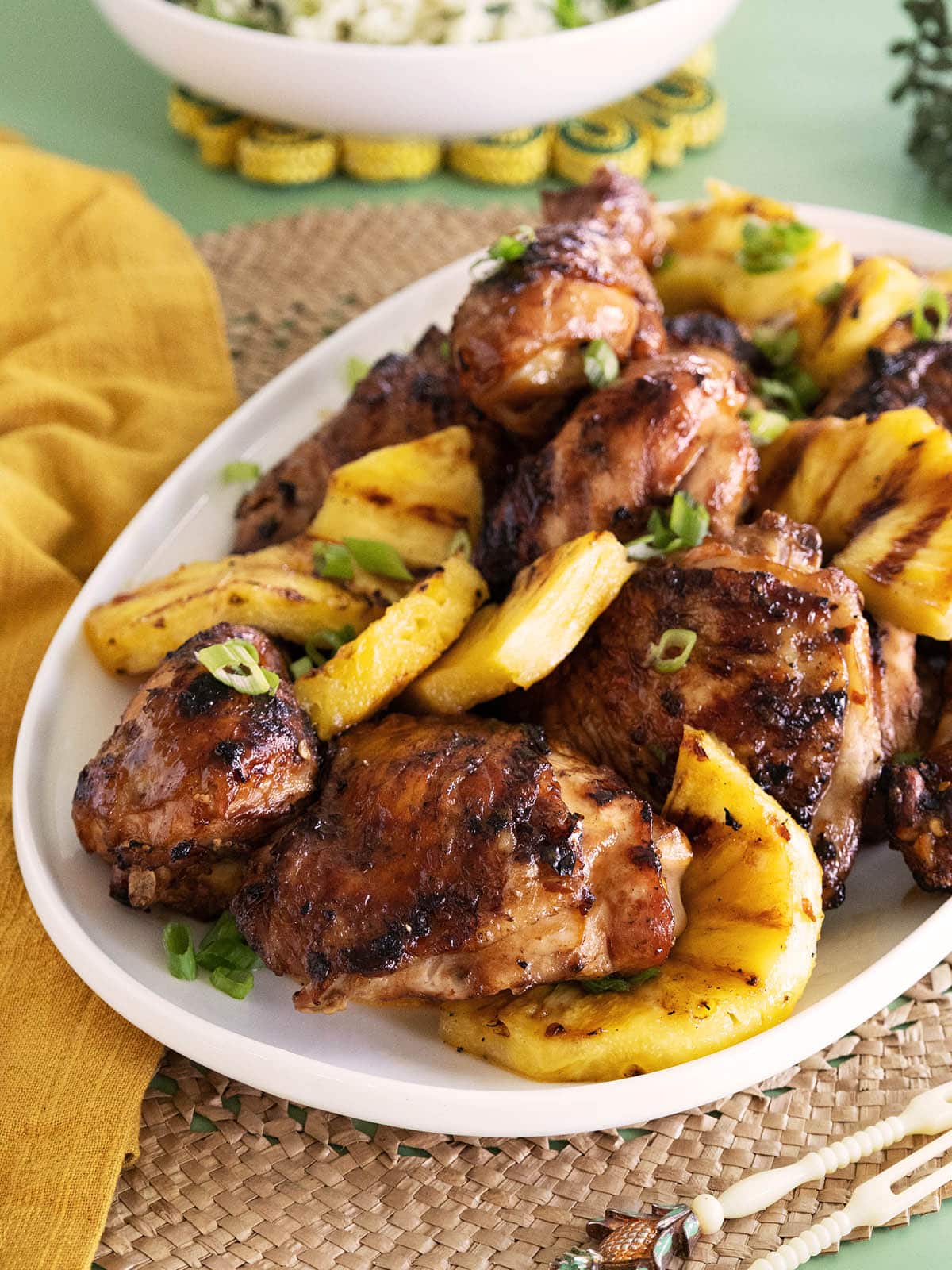 Grilled chicken and pineapple on a white platter. 