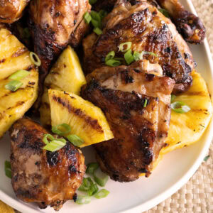 Close up of grilled chicken and grilled pineapple.