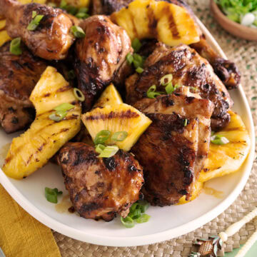 A platter topped with chicken and grilled pineapple.