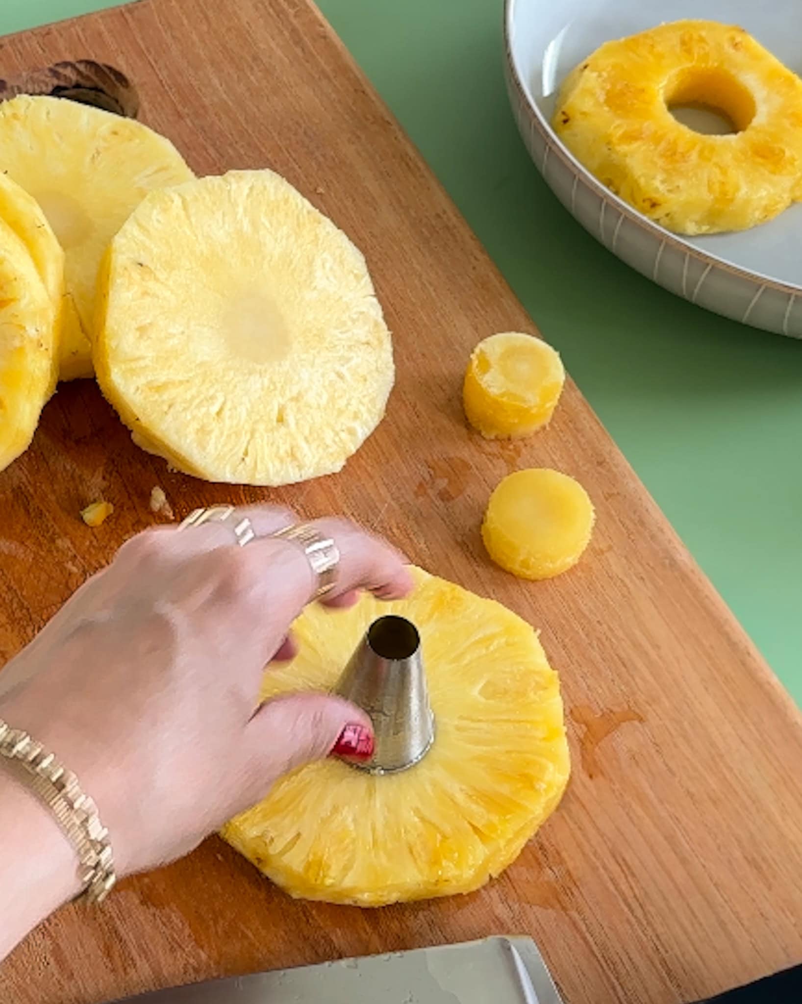 Using a pineapple corer to cut the center out of pineapple rings.