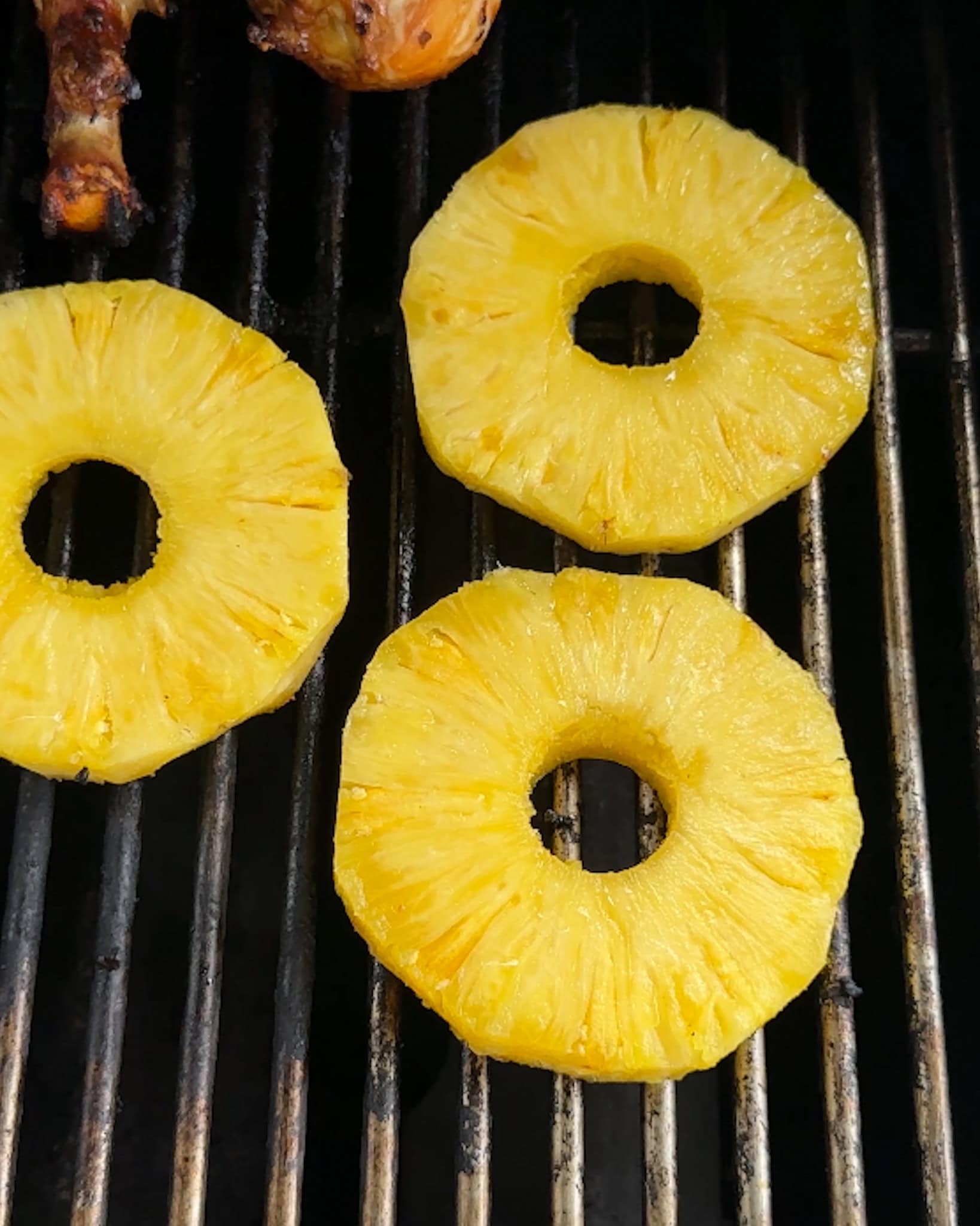 Three pineapple rings on a grill.