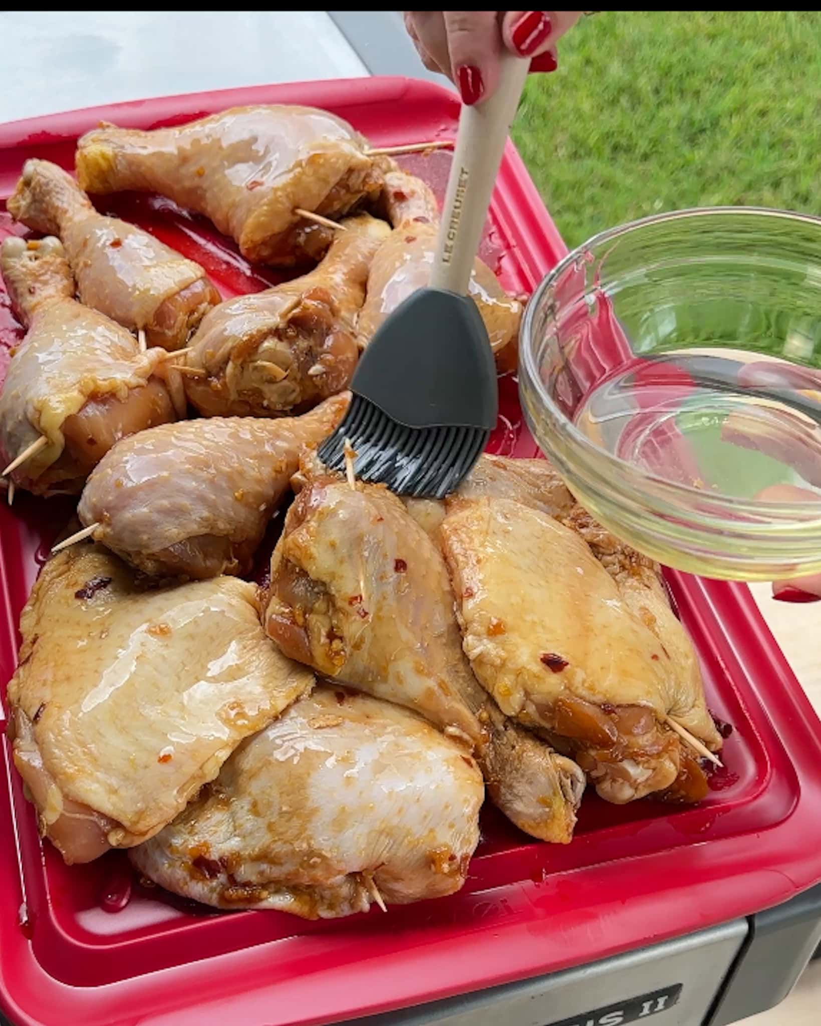 Brushing oil onto the outside of the chicken.