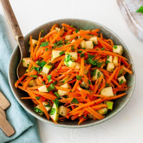 carrot salad with apples in a green bowl feature image