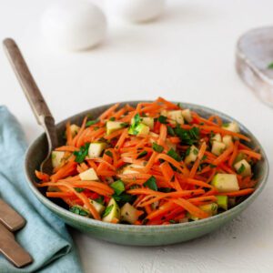 shredded carrots and apples in a bowl with a spoon feature image