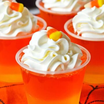 candy corn jello cups with whipped cream for halloween treats.