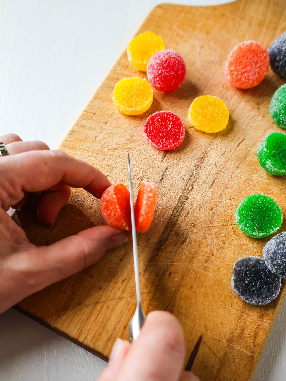 Cutting a large gumdrop in slices to use as candy eyes on cupcakes.