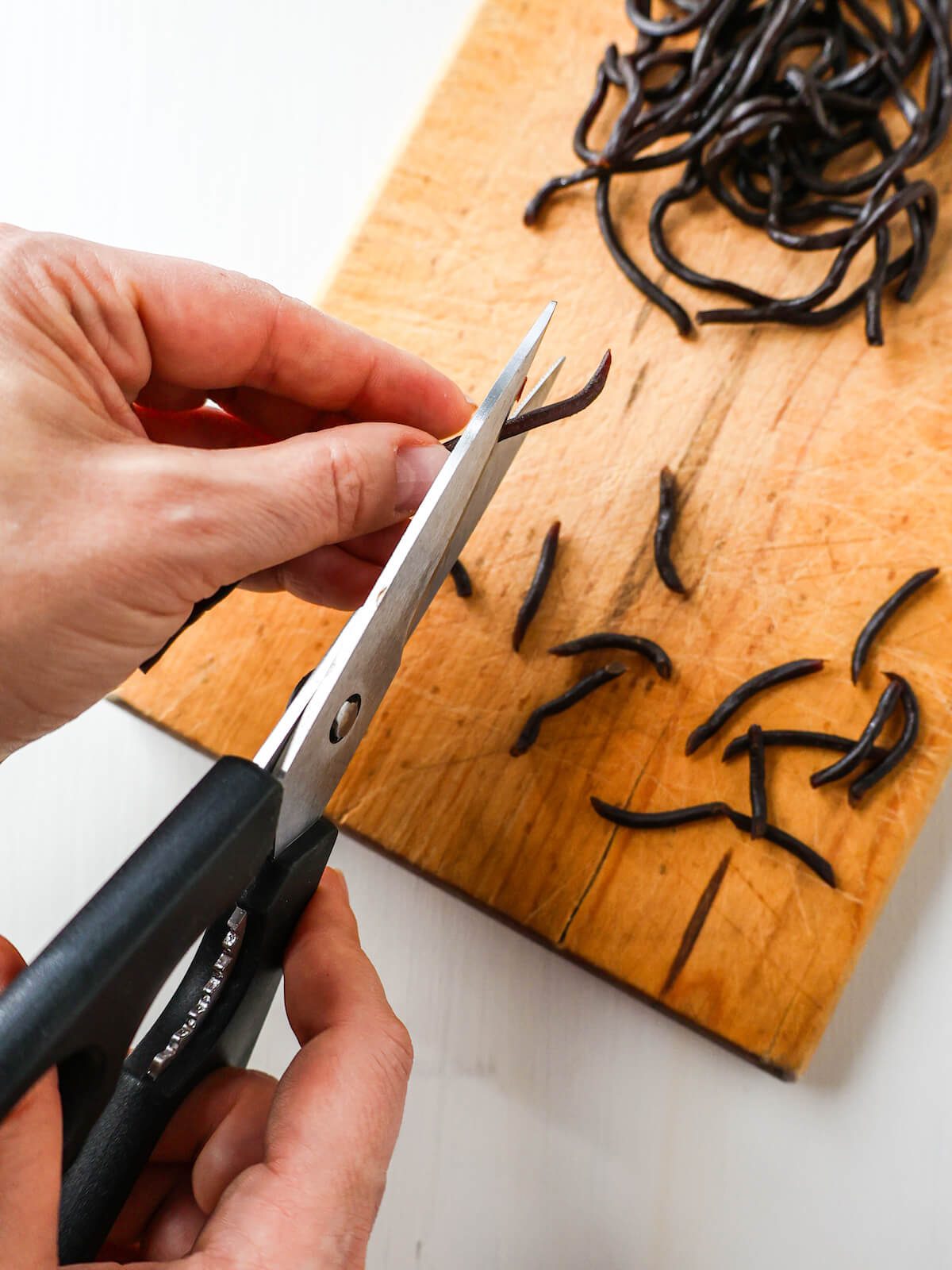 Cutting licorice laces with kitchen shears to create little candy eyelashes.