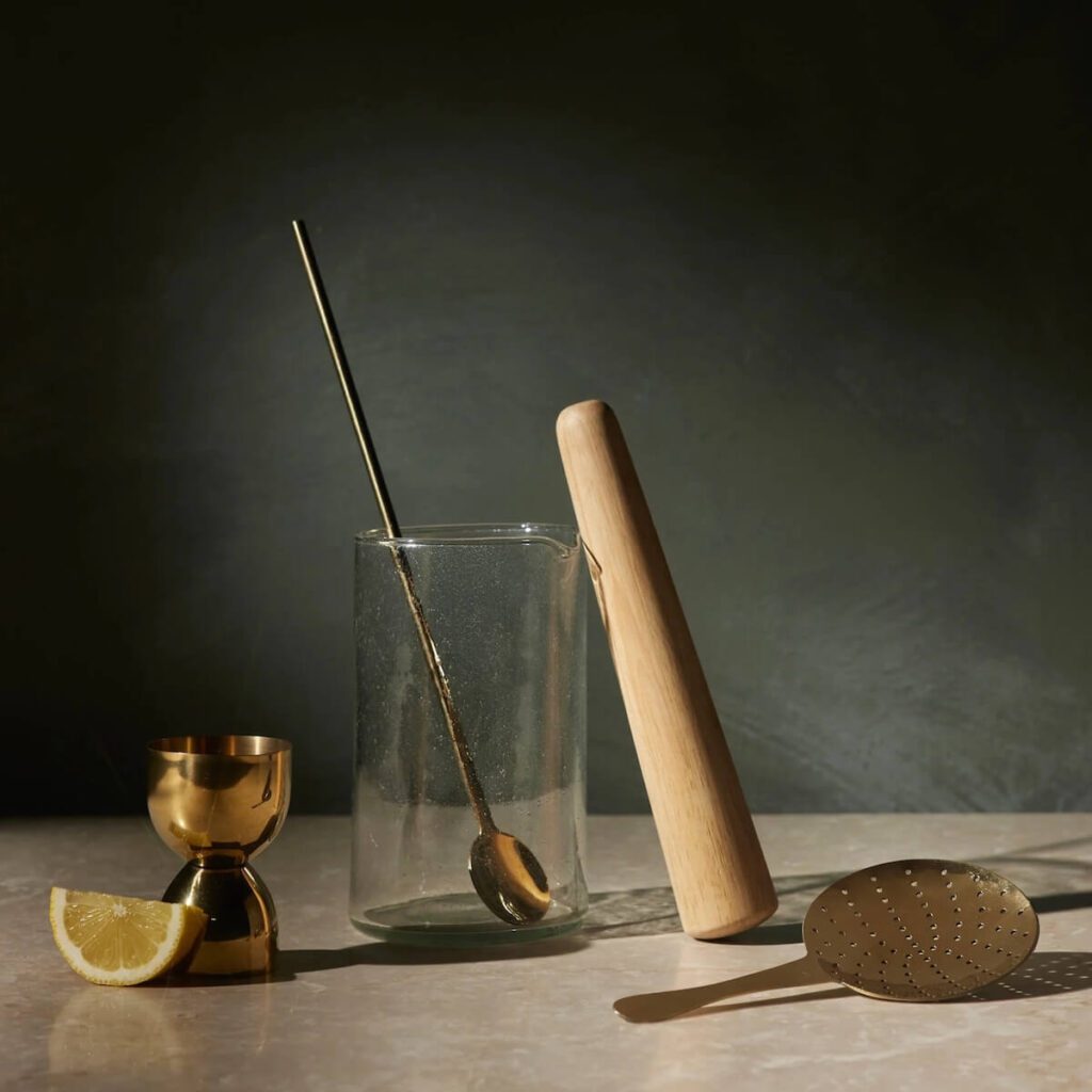 5 piece Pembrooke Cocktail set made from glass, gold plated stainless stele, and wood.