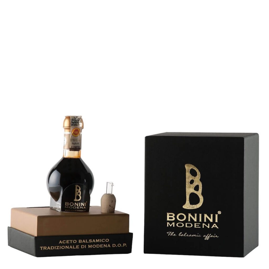 A bottle of Piro's balsamic vinegar called Bonini Modena in a small, clear glass container.