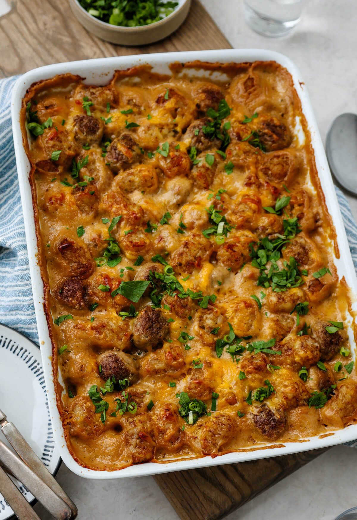 A full pan of cheesy meatball casserole with tater tots baked in a cream sauce.