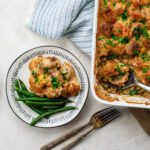 close up of meatball potato casserole on a plate with green beans.