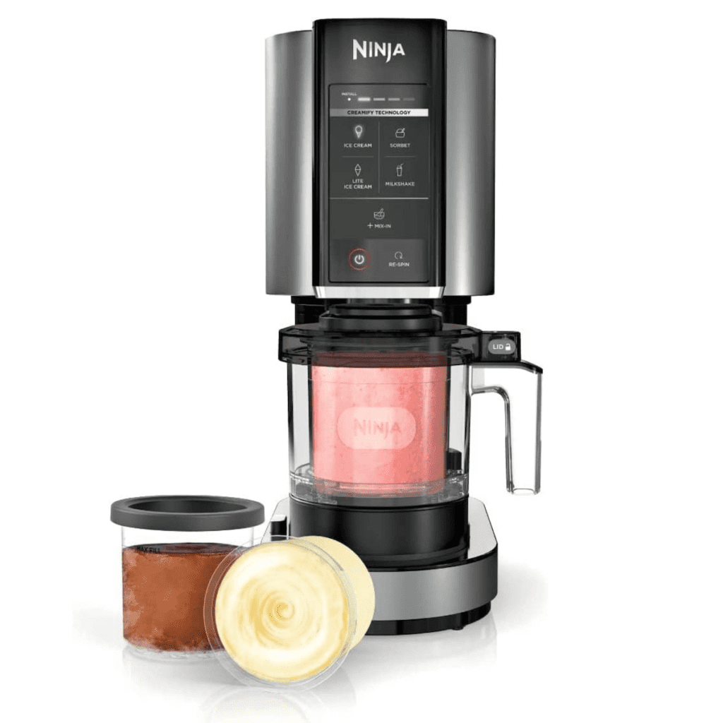 The black ninja creami ice cream maker with a pink frozen treat being blended and two containers of already blended chocolate and vanilla frozen treats off to the side.
