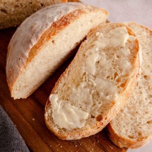 Sourdough bread with yeast sliced and spread with butter feature image.