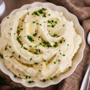 close up feature image of mashed potatoes with fresh herbs on top.
