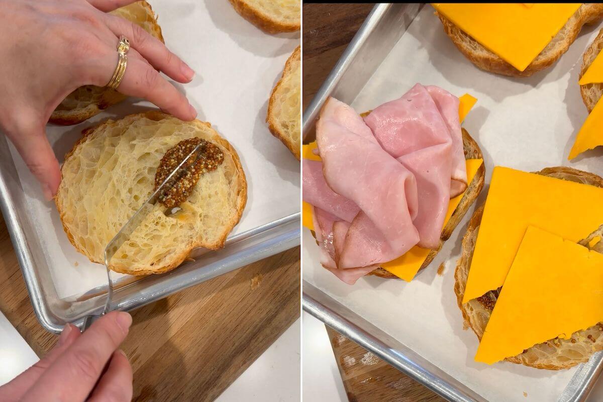 spreading dijon mustard on a croissant and placing amrican cheese and ham on the croissant for a croissant breakfast sandwich.