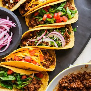 Close up of corn tortilla beef tacos on a platter.