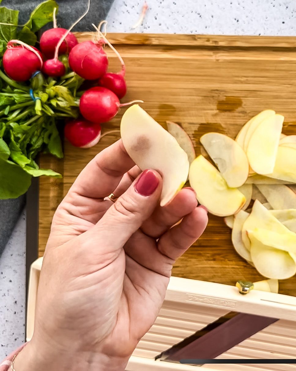 Mandoline slicer cutting apples paper thin.