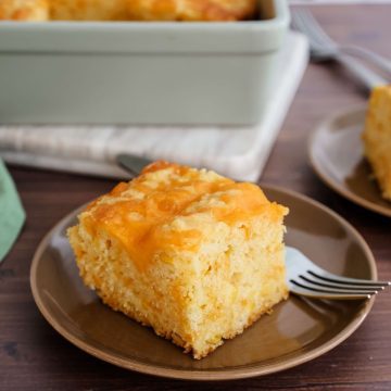 Feature image of a square of cheesy cornbread on a plate.